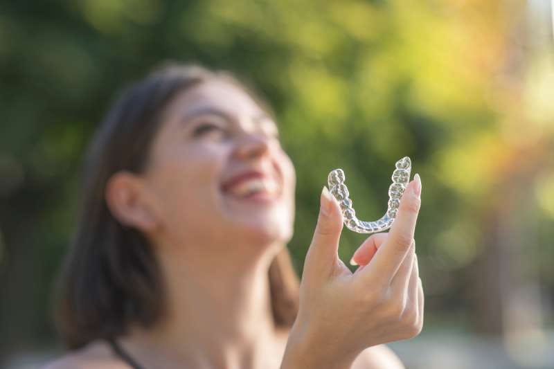 Women holding her Clear Aligner and smiling